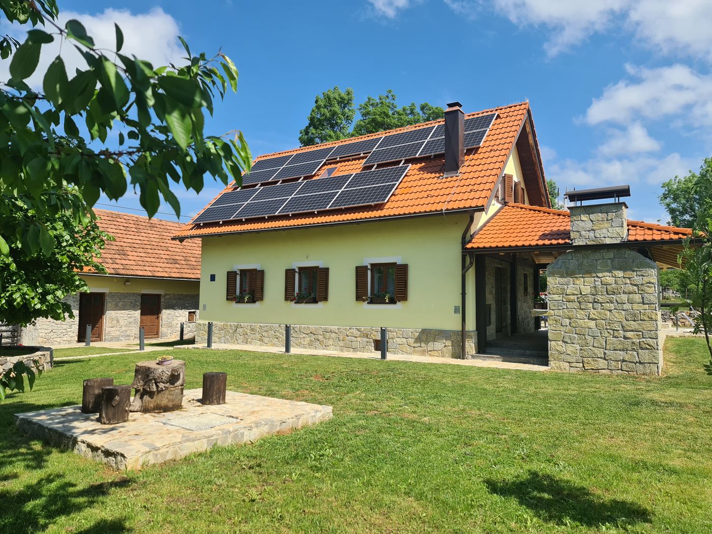 Kuća sa solarnim panelima i travnjakom