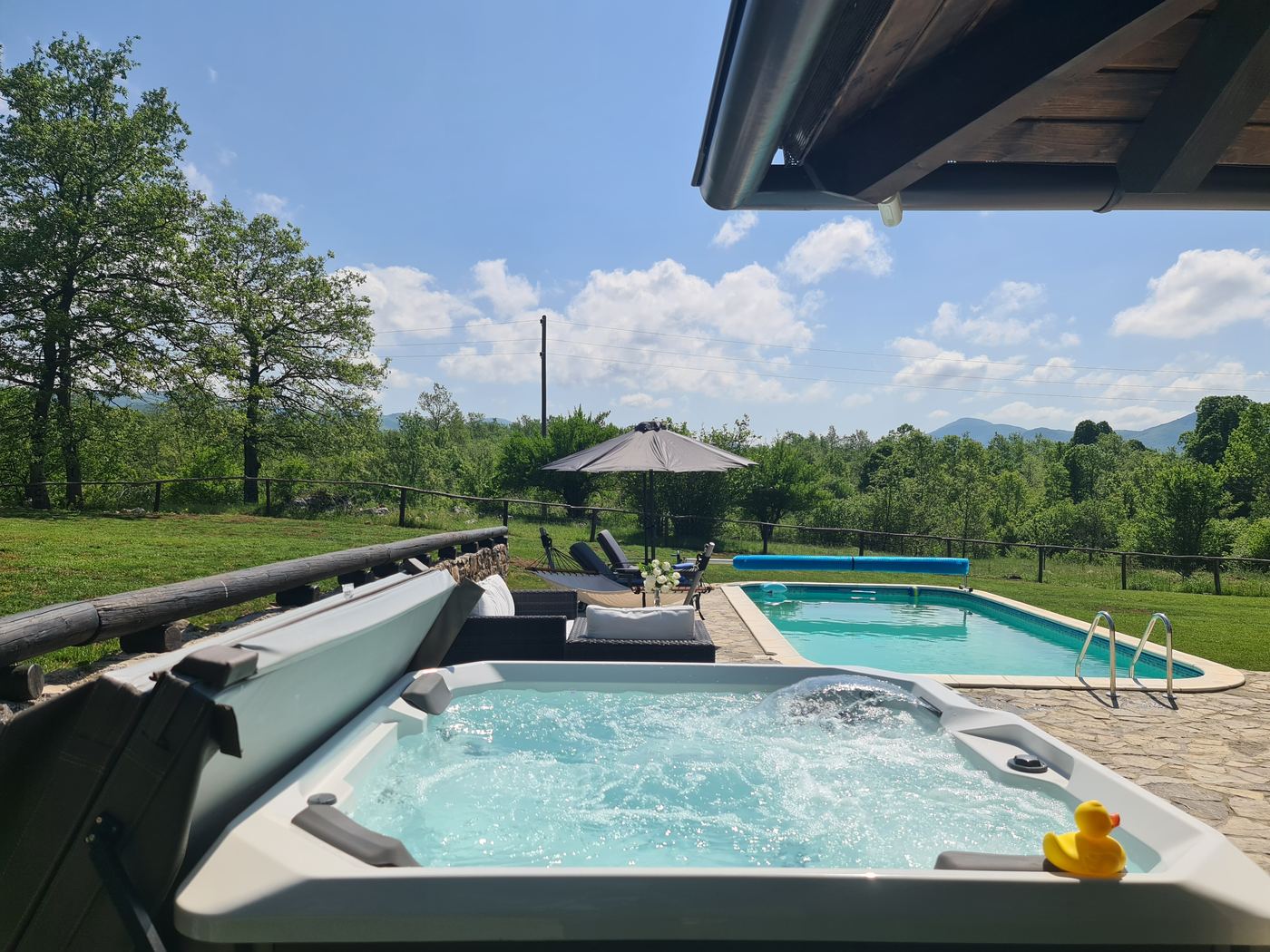 Jacuzzi uz bazen okružen zelenilom