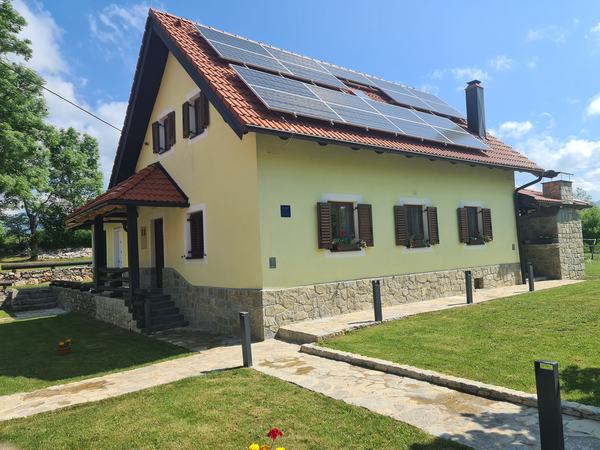 La casa con i pannelli solari e il portico d'ingresso