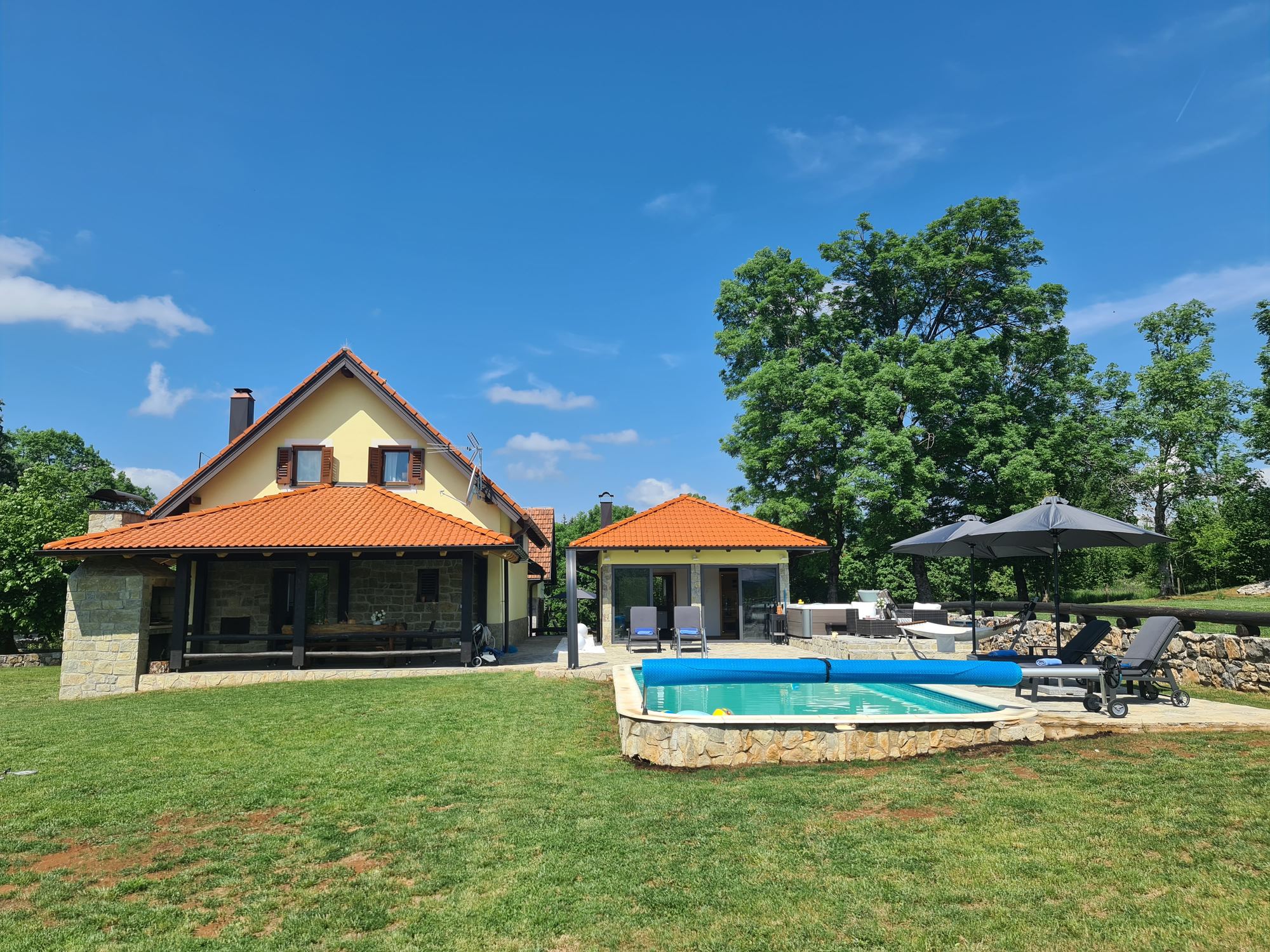 La casa, la piscina e l'edificio spa su un ampio prato