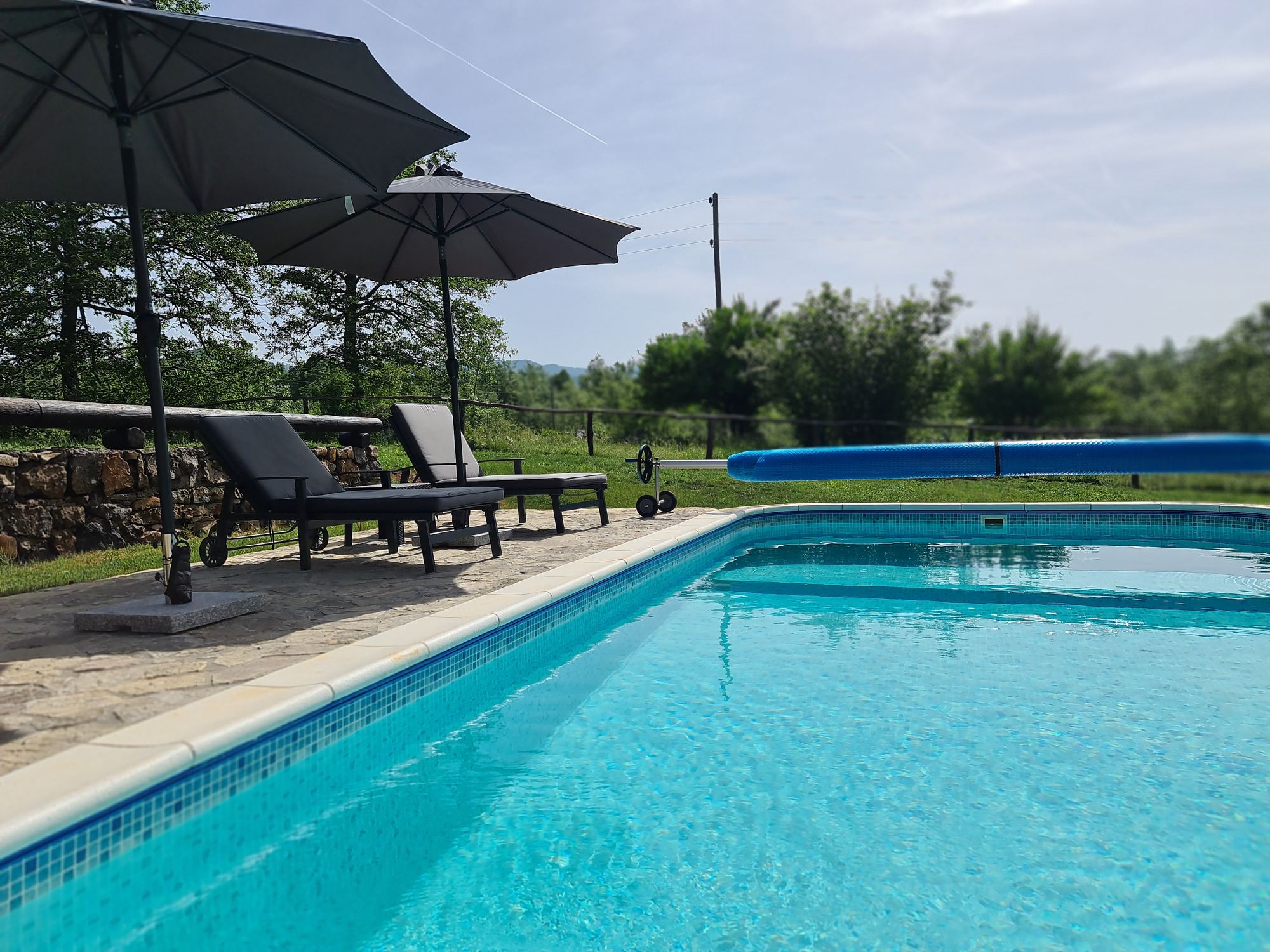 Piscina riscaldata con lettini e ombrelloni