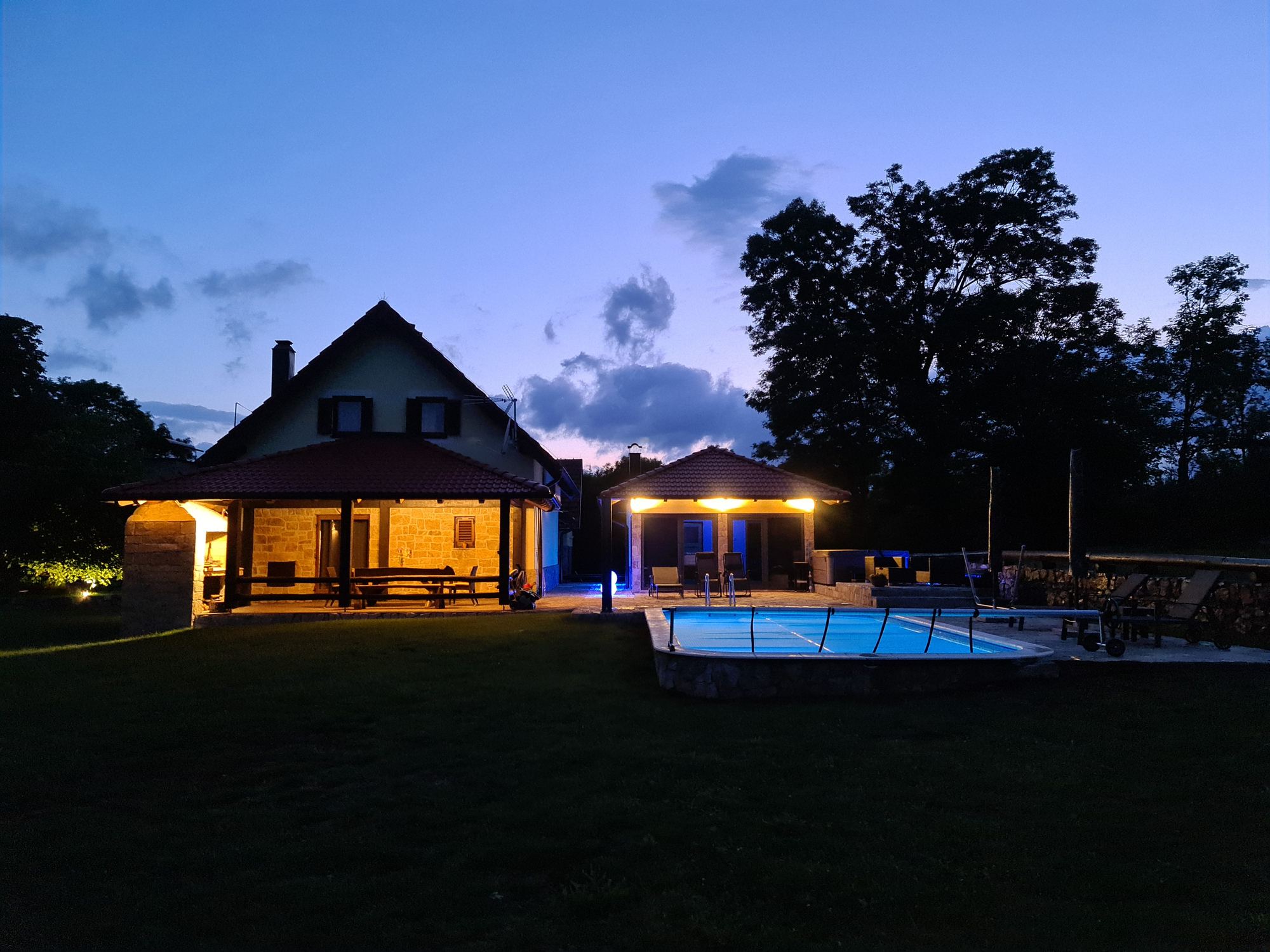 La villa e la piscina illuminata al tramonto