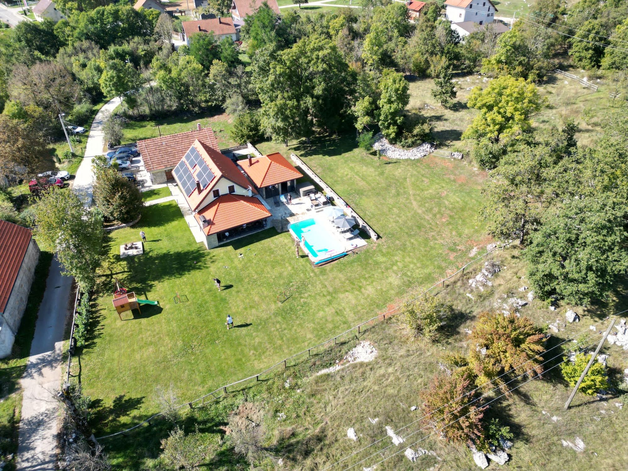 La villa con piscina e il paese dall'alto, immersi nel verde