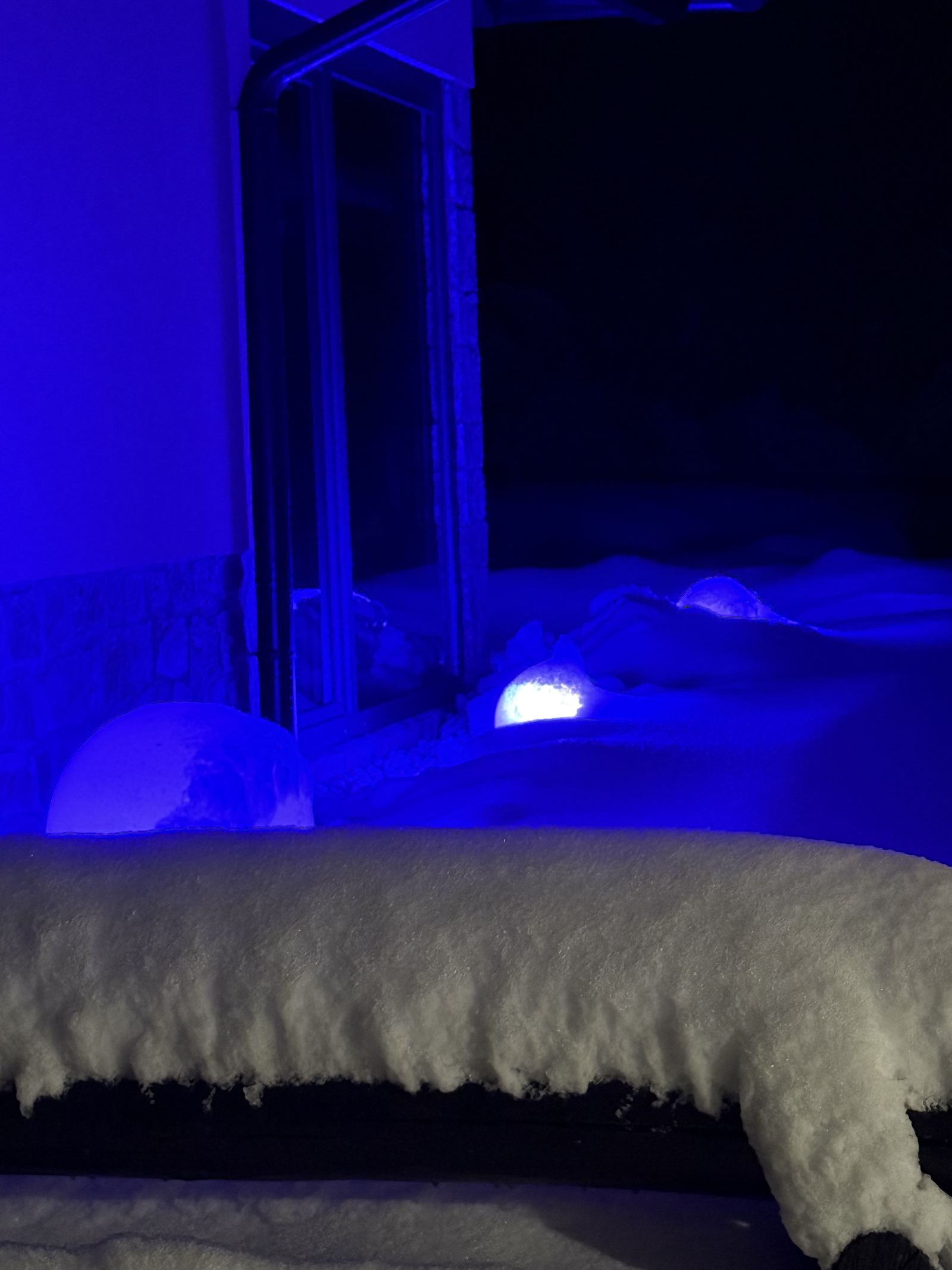 Vasca idromassaggio con luce blu in una notte di neve