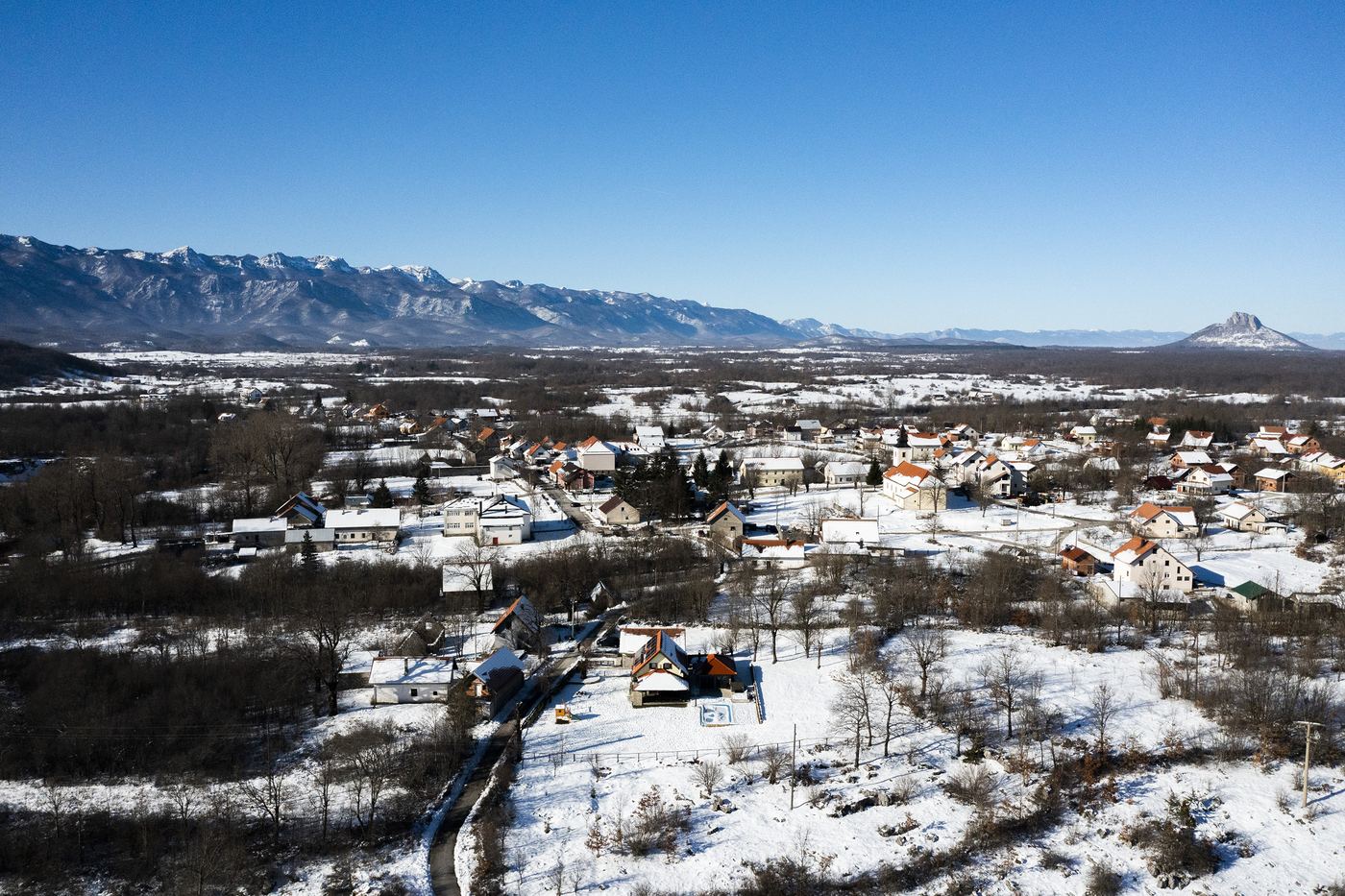 Lovinac pod snijegom, iza njega Velebit